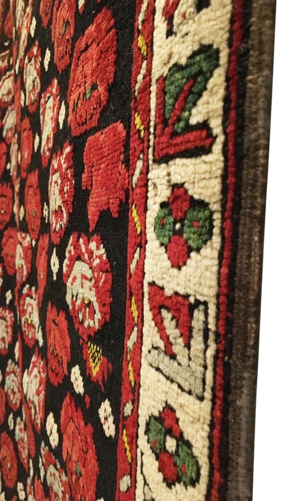 Close-up of a patterned fabric with red, green, and beige colors.
