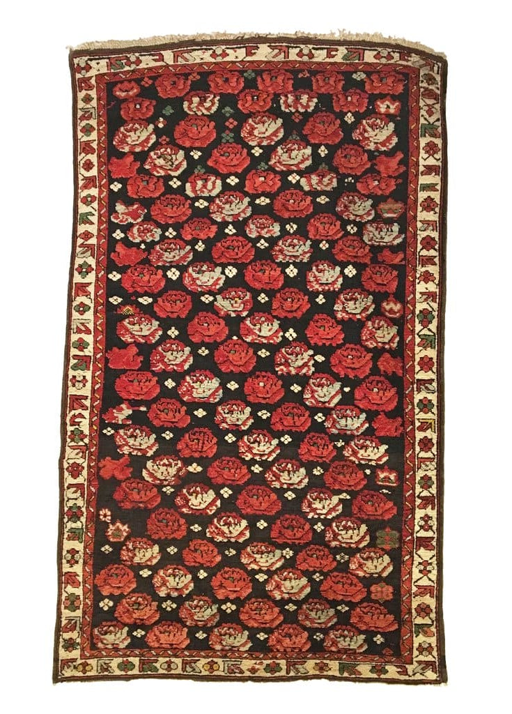 Decorative rug with red and beige floral patterns on a black background
